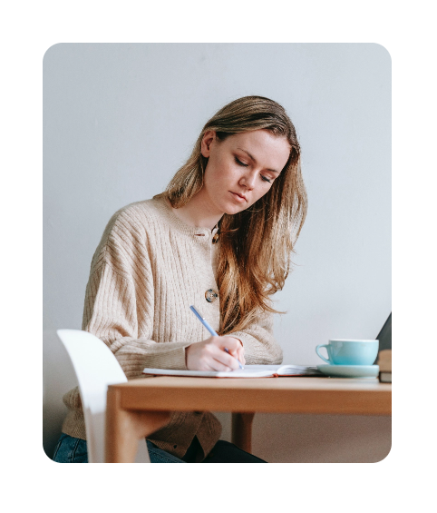 Focused Woman Writing in Notebook - GeorgiaTek Systems